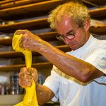 Elastisch, glänzend und gelb. Mit bloßen Händen teilt Arno Antongnini den Vorteig für die unterschiedlichen Panettone-Sorten Tradizionale, Nostrano und Pandananas / © Foto: Georg Berg