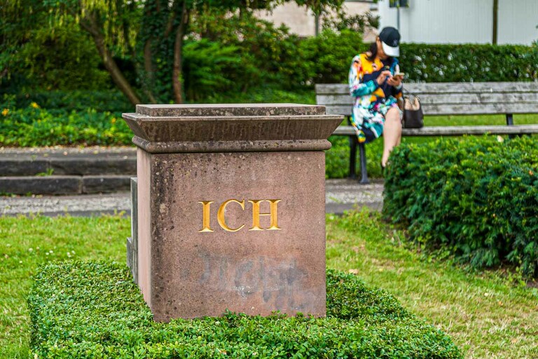 Nous avons dû attendre longtemps pour cette photo. En effet, la dame sur le banc du parc a mis un temps fou à se prendre en photo sur le socle grâce à un selfie stick / © Photo : Georg Berg