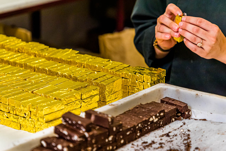 Le best-seller de la chocolaterie Frigoulette est emballé à la main dans du papier doré. La praline Malakoff de la Chocolaterie Frigoulette est disponible dans toute la France et particulièrement appréciée à Noël. Malakoff fait partie des pralines à la coupe qui se passent d'une enveloppe supplémentaire autour du noyau. Les noisettes grillées confèrent à la praline une consistance croustillante / © Photo : Georg Berg