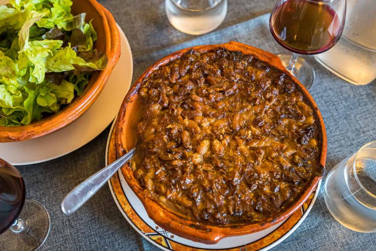 Le chef Eric Rousselot prépare le fameux cassoulet impérial à l'Hostellerie Etienne, une entreprise familiale depuis 1956. La croûte brune fait partie intégrante d'un bon cassoulet. Une simple salade et un verre de vin - c'est tout - c'est bien ! / © Photo : Georg Berg