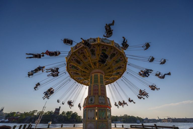 Gröna Lund, situé sur l'île-musée de Djurgården, est le plus ancien parc d'attractions de Suède. Il a été fondé en 1883 par l'Allemand Jacob Schultheiss. Le parc d'attractions se divise en une partie ancienne et une partie nouvelle. Ici, le manège à chaîne nostalgique au soleil couchant. Il est situé directement au bord de l'eau / © Photo : Georg Berg