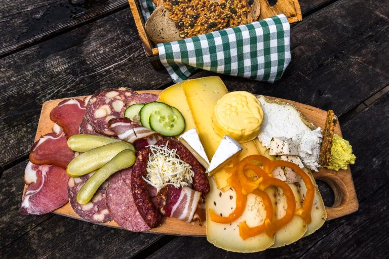 Repas de midi sur l'alpage de Filzmoos. Le fromage aigre, le camenbert, le beurre, le fromage en tranches, le lard, le jambon et la saucisse avec le pain proviennent de notre propre production / © Photo : Georg Berg