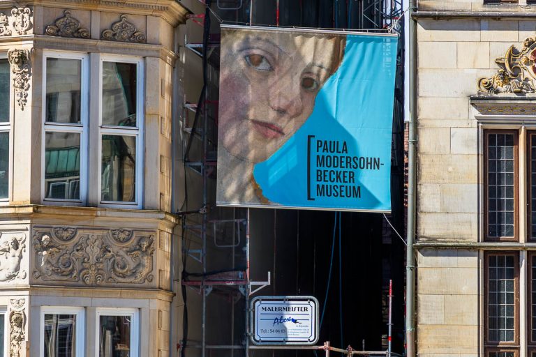 Bannière publicitaire pour le musée Paula-Modersohn-Becker dans la Böttcherstrasse à Brême. Il s'agit du premier musée au monde consacré à une peintre et il a été ouvert en 1927. Il a été commandé par le fondateur et mécène du café HAG, Ludwig Roselius, et construit par le sculpteur Bernhard Hoetger / © Photo : Georg Berg