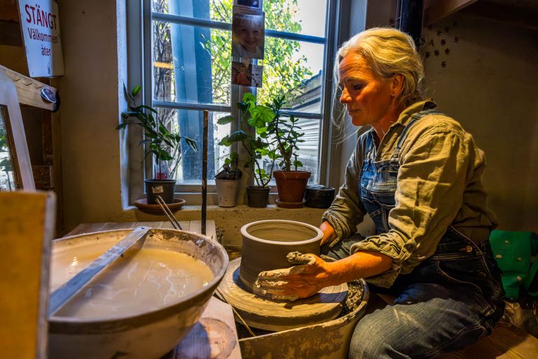 Lisa Wohlfahrt au tour de potier dans son atelier à Mölle. L'atelier de céramique se trouve au pied du Kullaberg et est connu pour ses céramiques faites à la main et durables. Chaque pièce passe par jusqu'à 15 étapes de traitement avant d'être achevée et est unique. Les produits sont fabriqués aussi bien dans le propre magasin que pour des occasions spéciales comme des mariages ou des commandes d'entreprises, Mölle Krukmakeri / © Photo : Georg Berg