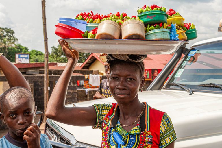 Marchande ambulante avec des piments rouges et verts en vente / © Photo : Georg Berg