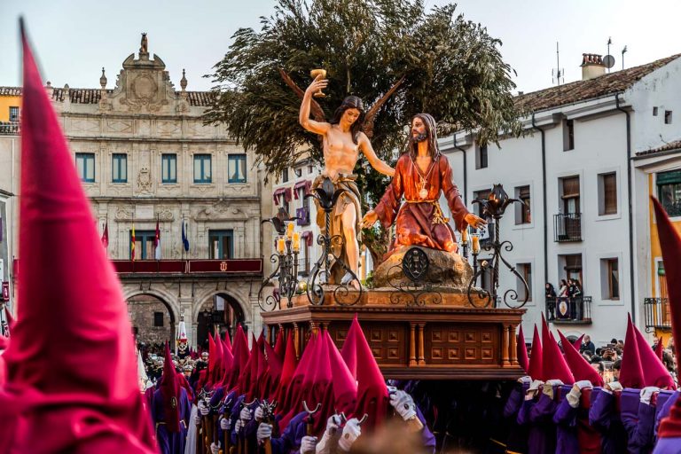 Procession en Espagne avec Jésus et un ange sur un char ; les pèlerins portent des robes rouges et violettes / © Photo : Georg Berg